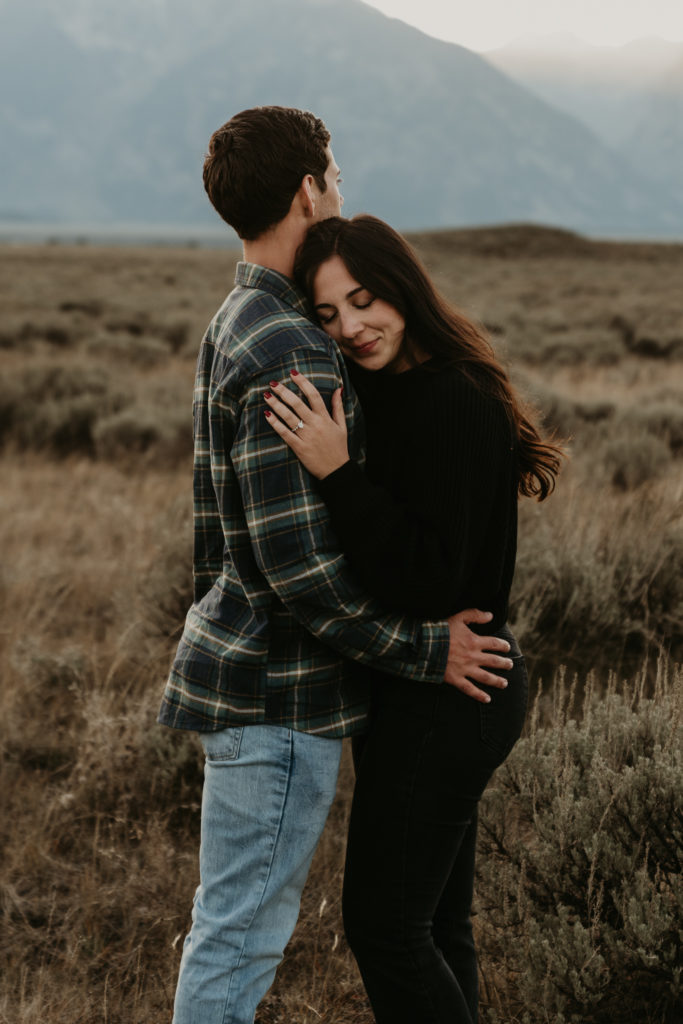 Couple hugs each other in a field